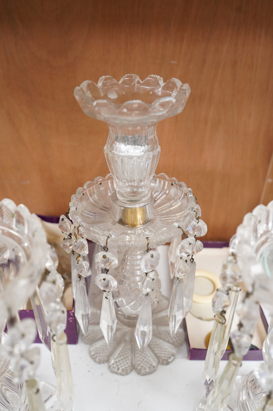 A pair of Victorian cut glass lustre candlesticks and one larger candlestick, 24cm high